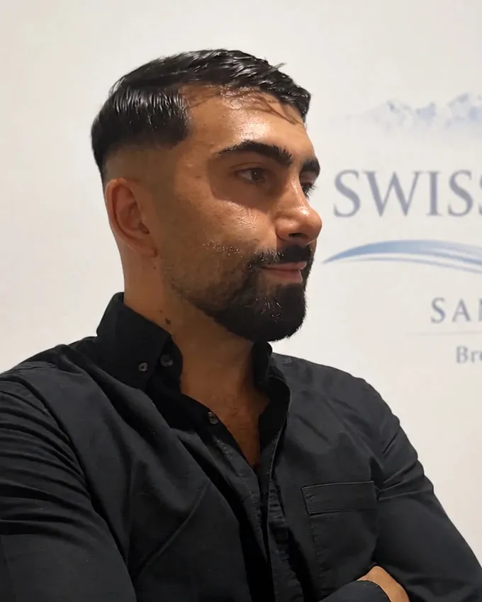 Ufuk Ozdemir, devant le logo de Swiss Léman Sanitaire
