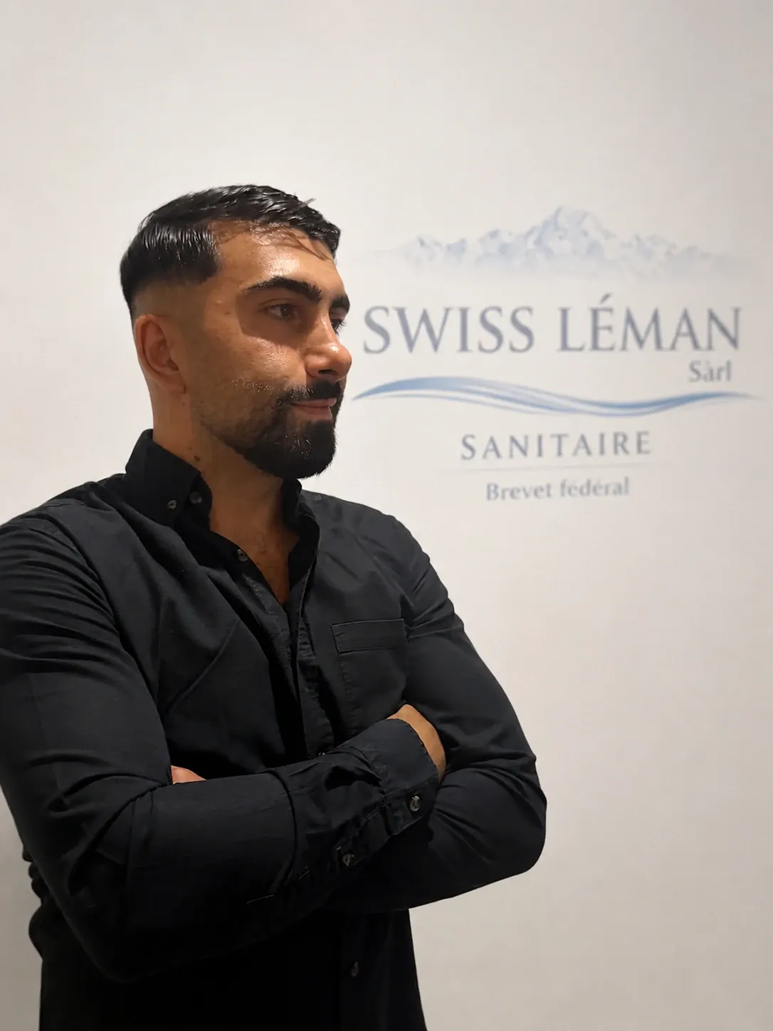 Ufuk Ozdemir, devant le logo de Swiss Léman Sanitaire